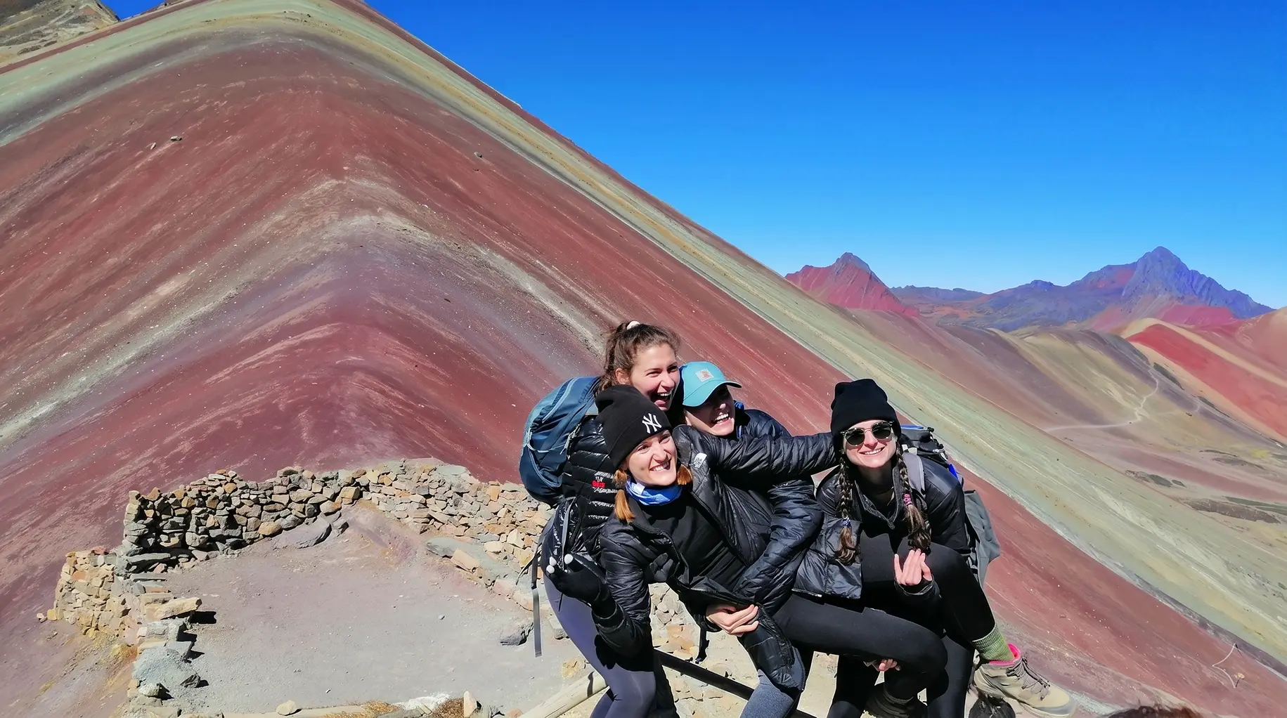 Hikers enjoying the vibrant mineral colors of Vinicunca Rainbow Mountain
